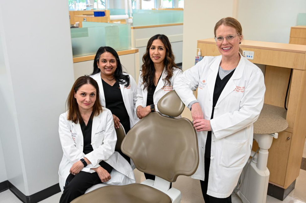 Center for Health Promotion team members gather around a dental chair for a group photo.