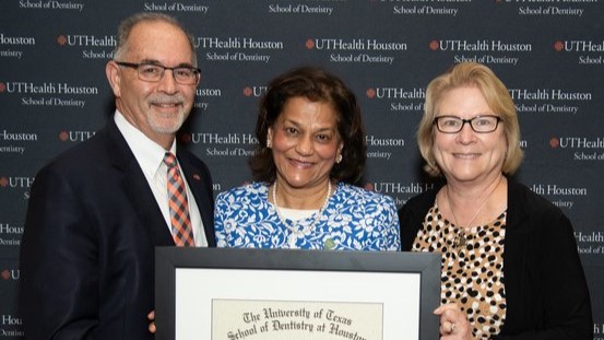 Dr. Rena D'Souza (middle) is presented her UTHealth Houston School of Dentistry Alumni Lifetime Achievement Award by Dr. John Valenza (left), dean, and Dr. Mary (Cindy) Farach-Carson, associate dean of research