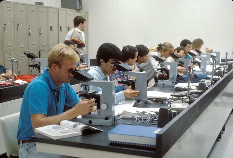 Students using microscopes in classroom lab