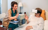 Caregiver helping elderly patient with Virtual Reality headset for rehabilitation