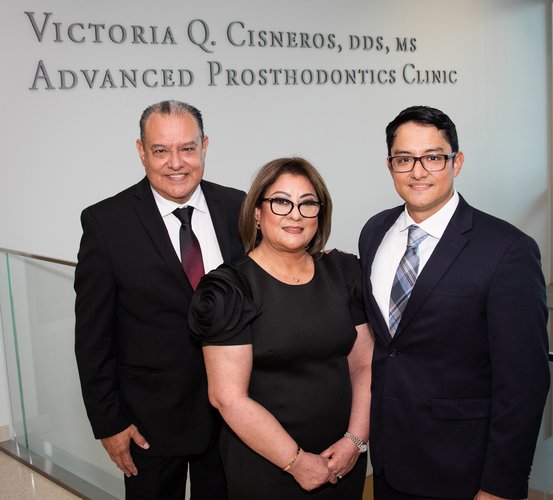 Dr. Victoria Cisneros (middle) stands with husband, Ricardo, and son, Ricky, in front of the Victoria Q. Cisneros, DDS, MS, Advanced Prosthodontics Clinic.