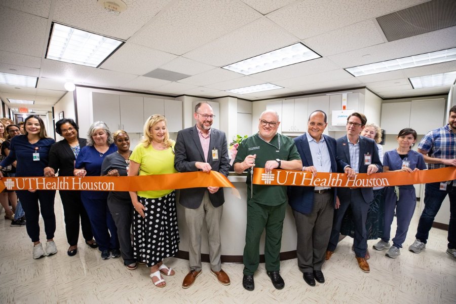 Joao de Quevedo, MD, PhD, cuts the ribbon for a new interventional psychiatry clinic surrounded by UTHealth Houston faculty and staff. (Photo by: Logan Ball, UT Physicians)