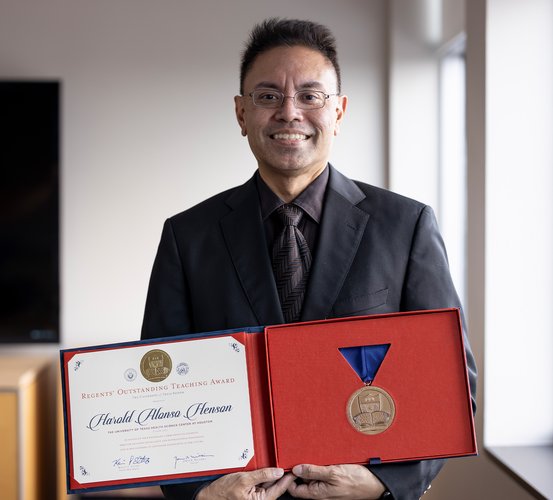 Dr. Harold Henson holds his 2021 UT System Regents’ Outstanding Teaching Award certificate and medallion.