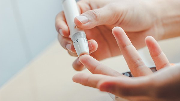 Photo of someone using a diabetes test device on a finger (Photo credit: Getty Images)