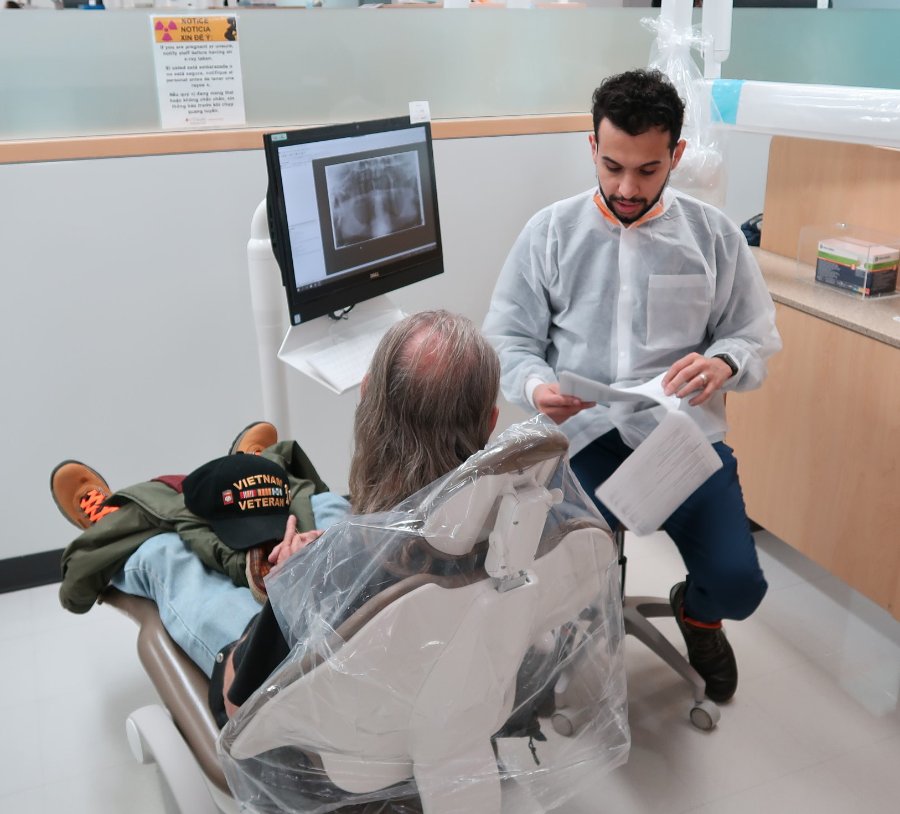 Dr. Abdulrahman Alsulaimi, an AEGD resident, reviews medical  history with his patient, a Vietnam veteran.