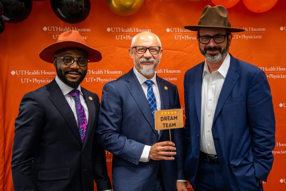 Martin Citardi, MD, Babatope Fatuyi, MD, MPH, and Amar Yousif, MBA standing in front of an orange UT Health Houston backdrop