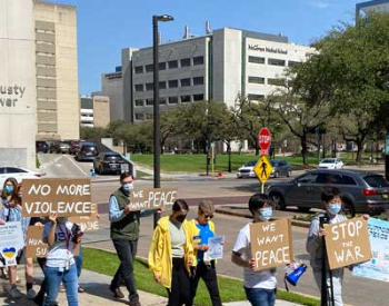 Photo of a group of students marching in the TMC with signs. (Photo by UTHealth Houston)
