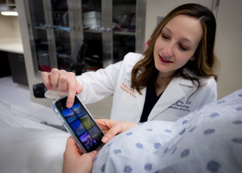 Photo of Morgen Doty, DO, a maternal-fetal medicine fellow at McGovern Medical School, demonstrates how to access mindful meditation programs on the free app. (Photo by Maricruz Kwon/UTHealth)