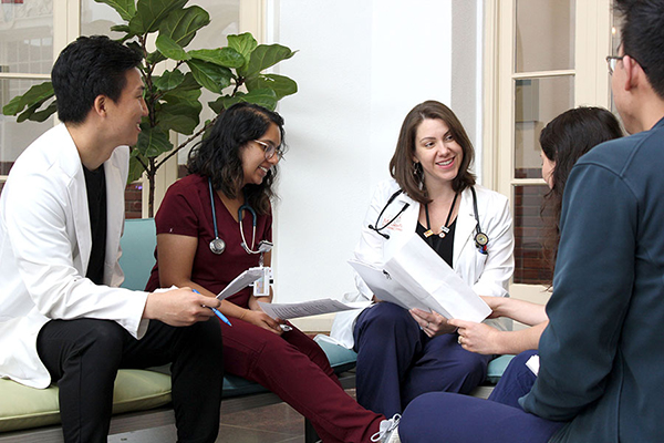 Close-up of Dr. Jantea having a discussion with a male and female couple while two other doctors listen
