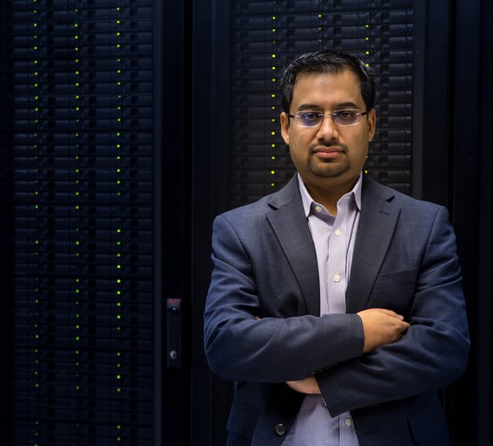 Dr. Muhammad Walji stands in front of data-processing servers.