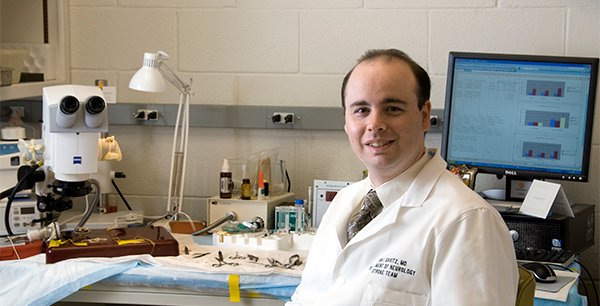 Photo of Dr. Sean Savitz seated in his laboratory. He has been researching stem cells for more than a decade and is the author of a paper published in the journal Stem Cells.