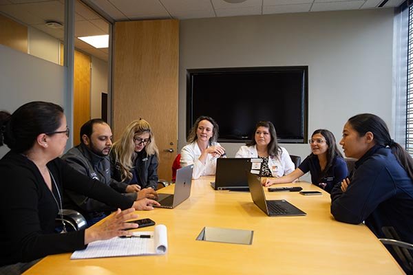 Photo of the surgeons in the Comprehensive Congenital Colorectal Program at UTHealth meeting together as a group to discuss a patient and decide on a treatment plan. (Photo by Rogelio Castro/UTHealth)