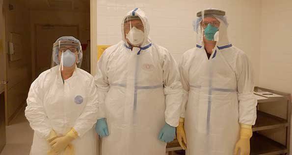 From left to right: Meena Bhattacharjee, MD, L. Maximilian Buja, MD, and Noah Reilly, DO in PPE before an autopsy. (Photo by Rongzhen Zhang, MD)