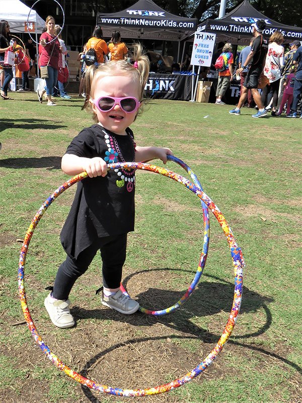 Photo of small child with hula hoops at Stomp Out Stroke Festival. Photo credit is UTHealth.