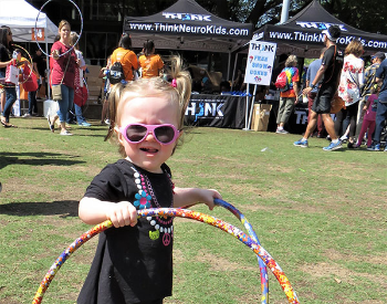 Photo of small child with hula hoops at Stomp Out Stroke Festival. Photo credit is UTHealth.
