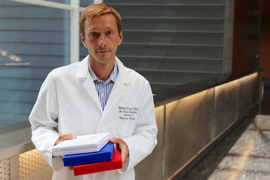 Mikhail Kolonin, PhD, holds test tubes in the IMM