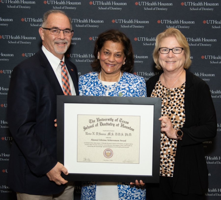 Dr. Rena D’Souza (middle) is presented her UTHealth Houston School of Dentistry Alumni Lifetime Achievement Award by Dr. John Valenza (left), dean, and Dr.  Mary (Cindy) Farach-Carson, associate dean of research.