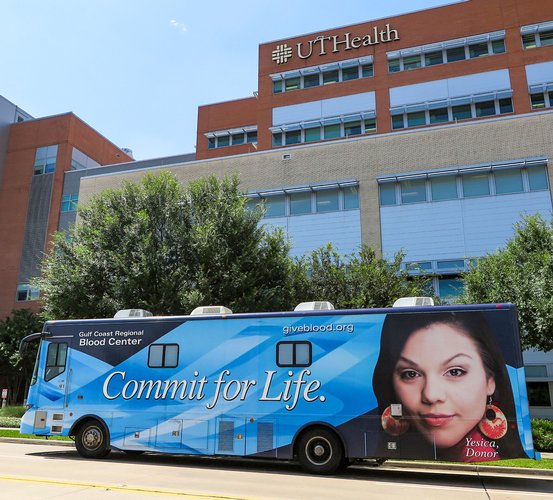 Gulf Coast Regional Blood Center donor coach parked outside UTHealth School of Dentistry.