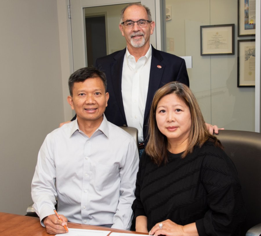 Dr. Don Le (left) and his wife, Cindy (right), pictured Dean John A. Valenza, DDS, while signing an endowment agreement with UTHealth Houston School of Dentistry.