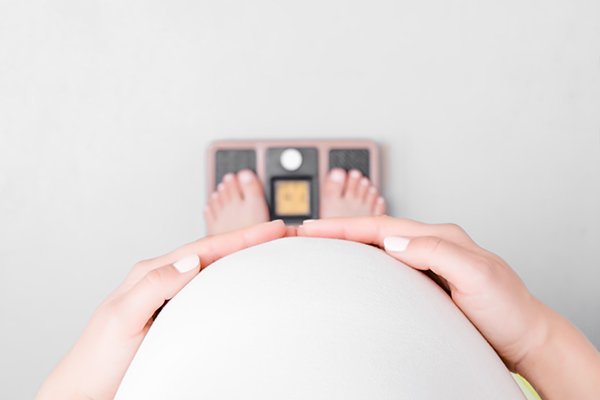 Photo of pregnant woman on a scale. (Photo credit: Getty Images)