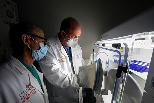 Photo of Ben Bobrow, MD, and Holger Eltzschig, MD, PhD, using the hypoxia chamber, which helped them discover that HIF activators could potentially treat damaged lungs. (Photo credit: Cody Duty/UTHealth)