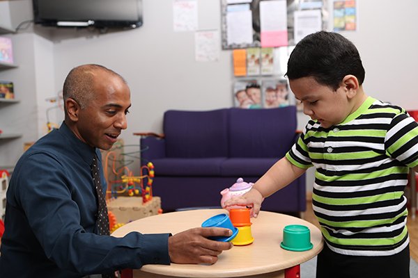 Photo of Anson Koshy, MD, a child development specialist, interacting with a patient. (Photo by Felix Sanchez)