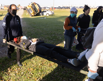 Students at the UTHealth Houston Mass Casualty Incident Training transport a victim away from the scene to receive medical attention. (Photo by Rogelio Castro/UTHealth Houston).