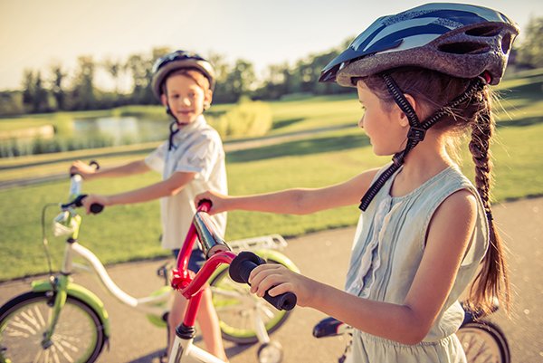 Photo of a boy and a girl on their bicycles. Photo credit is Getty Images.