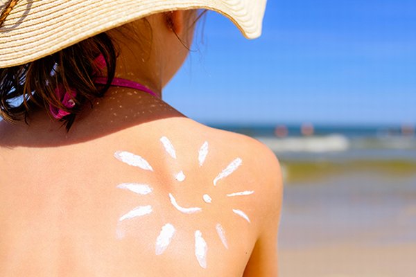 Photo of child wearing sunhat and sun cream. Photo credit is Getty Images.