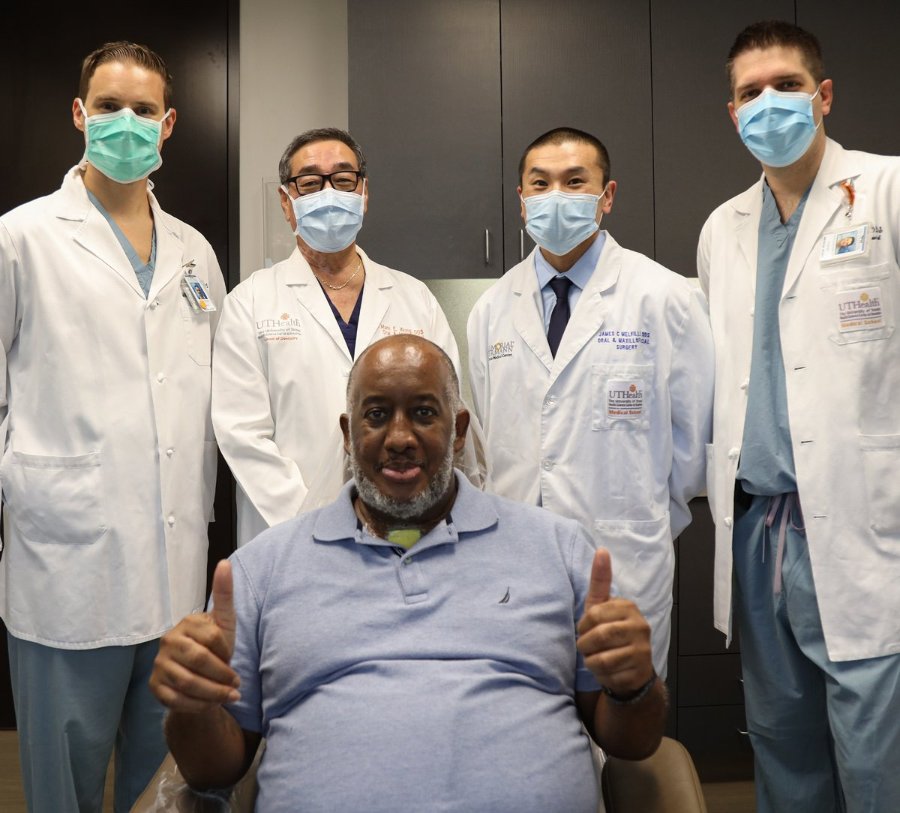 Anthony Jones with his with his surgical team (from left to right) Dominik Rudecki, DMD; Mark Wong, DDS; James Melville, DDS; and John Guenther, DMD, after a life-changing surgery. Photo by: Roger Castro.