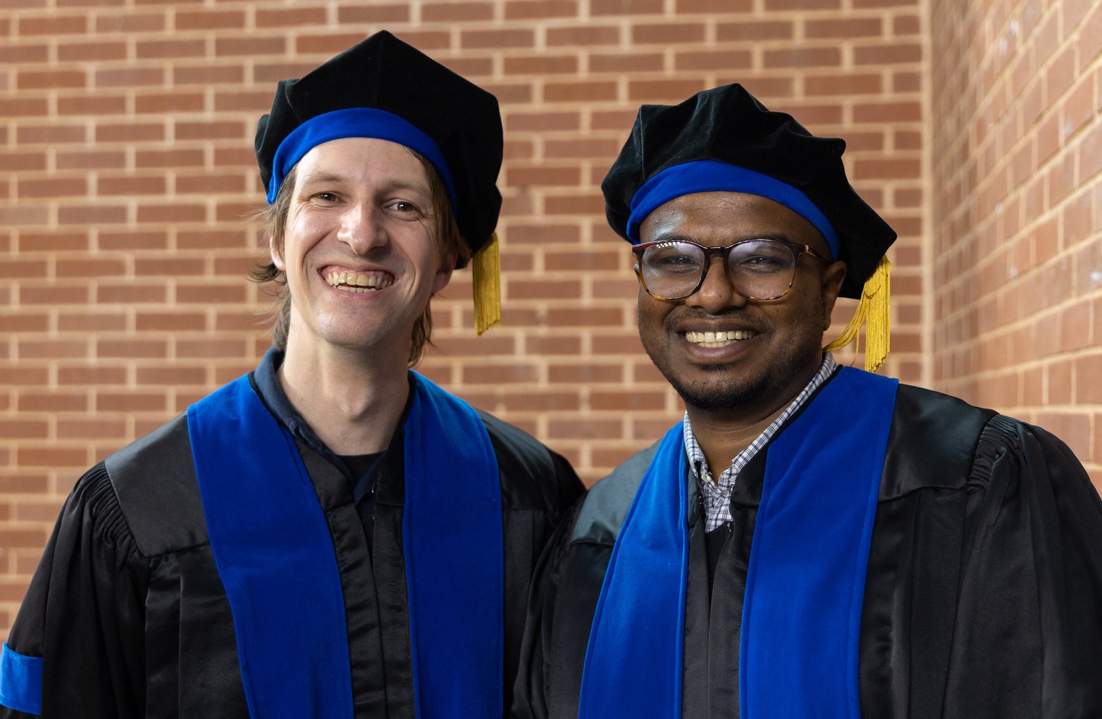 GSBS graduates Darlan Conterno Minussi, PhD, and Vinay Nair, PhD, are all smiles after receiving their doctoral degrees.