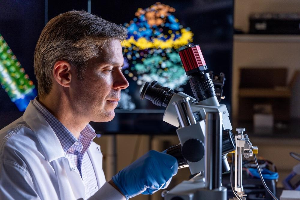 John P. Seymour, PhD, looking into microscope