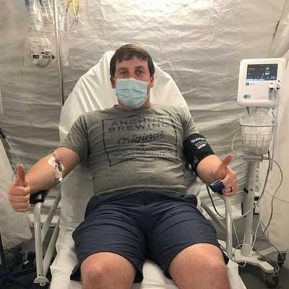 Photo of Brandon receiving an infusion of either LY-CoV555, an investigational monoclonal antibody developed from the blood sample of a recovered COVID-19 patient, or a placebo. (Photo by Brandon Hawthorne)