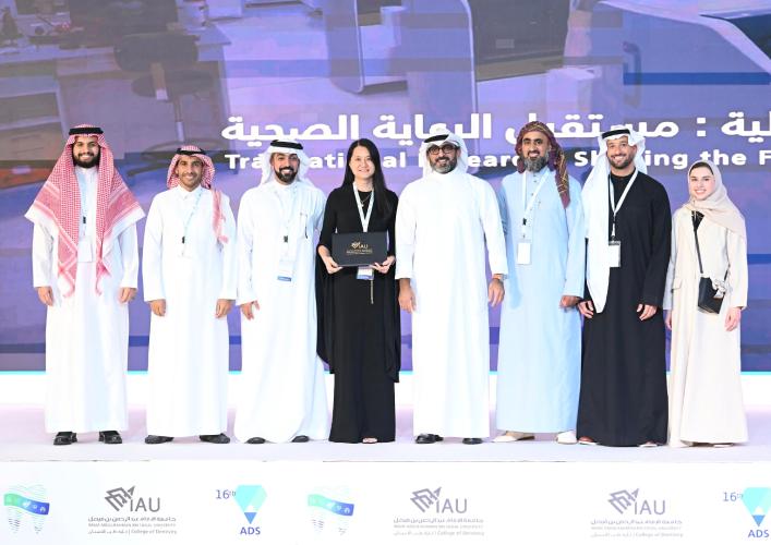 Large group of individuals stand shoulder to shoulder for a photo on stage.