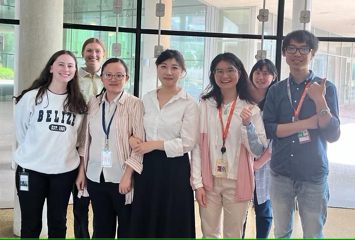 Fisher (left) and Huang (fourth from left) standing in a group with lab members in Cancer in a Dish lab.