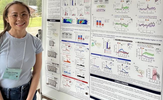 Chuong standing by poster.