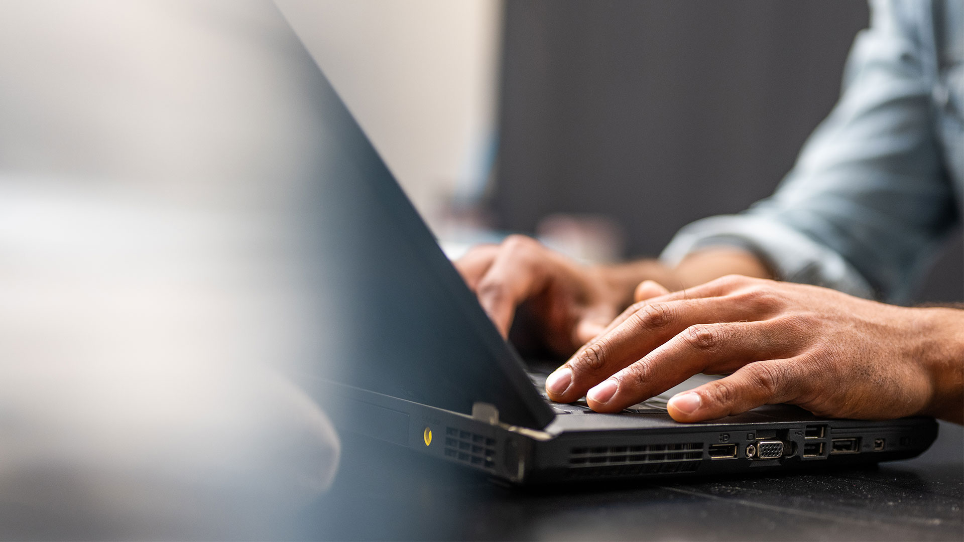 Hands typing on a laptop
