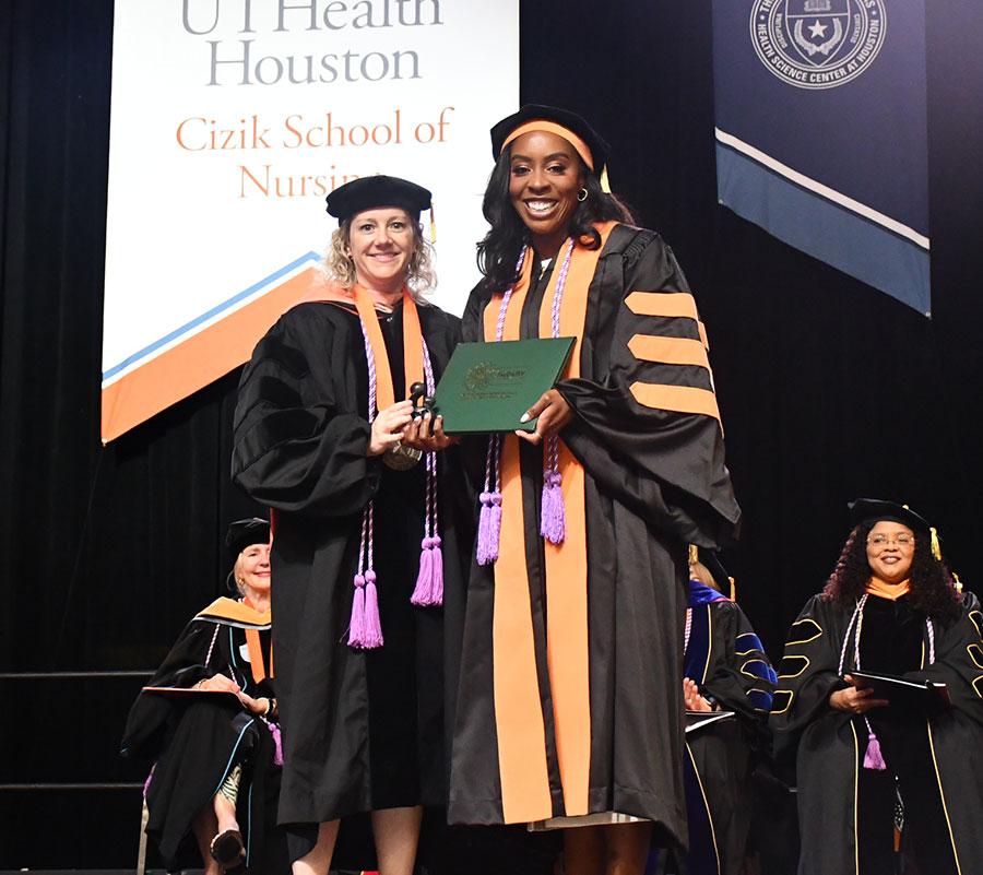 DNP graduate Laura Douglas receiving the DAISY Award from Dean Santa Maria.