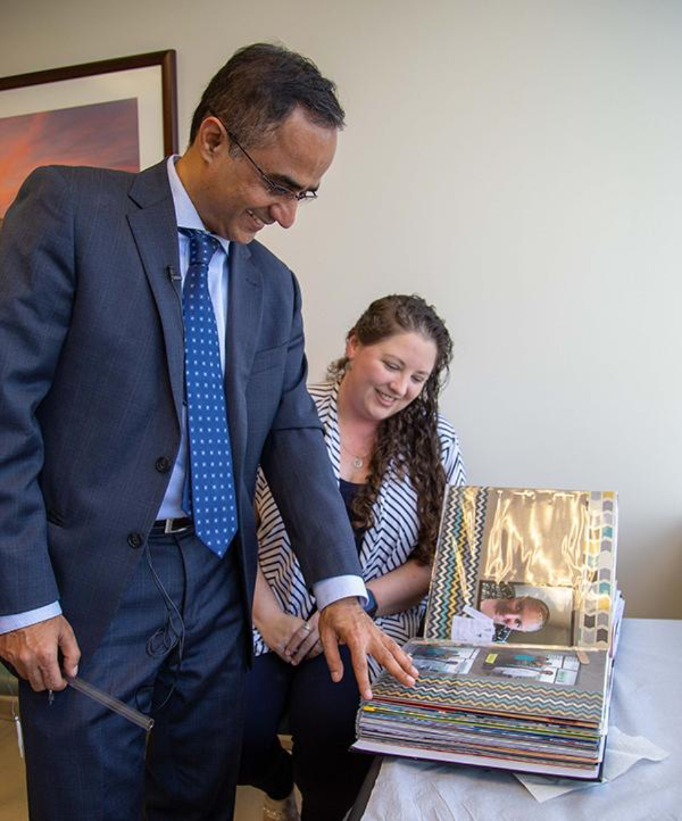 Photo of Nitin Tandon, MD, and Alisha Mehaffey studying her scrapbook. Photo credit is Maricruz Kwon/UTHealth