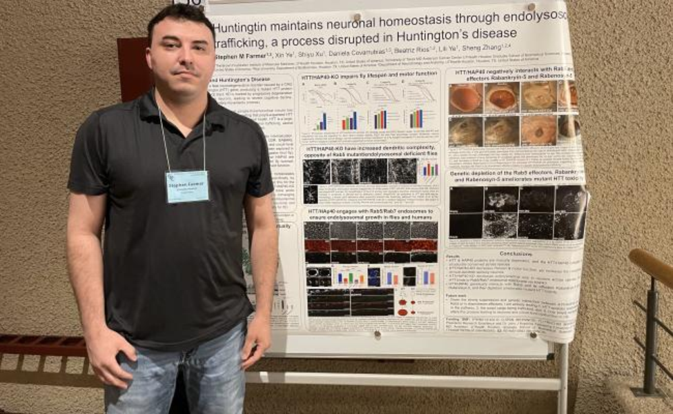 Farmer standing by poster.