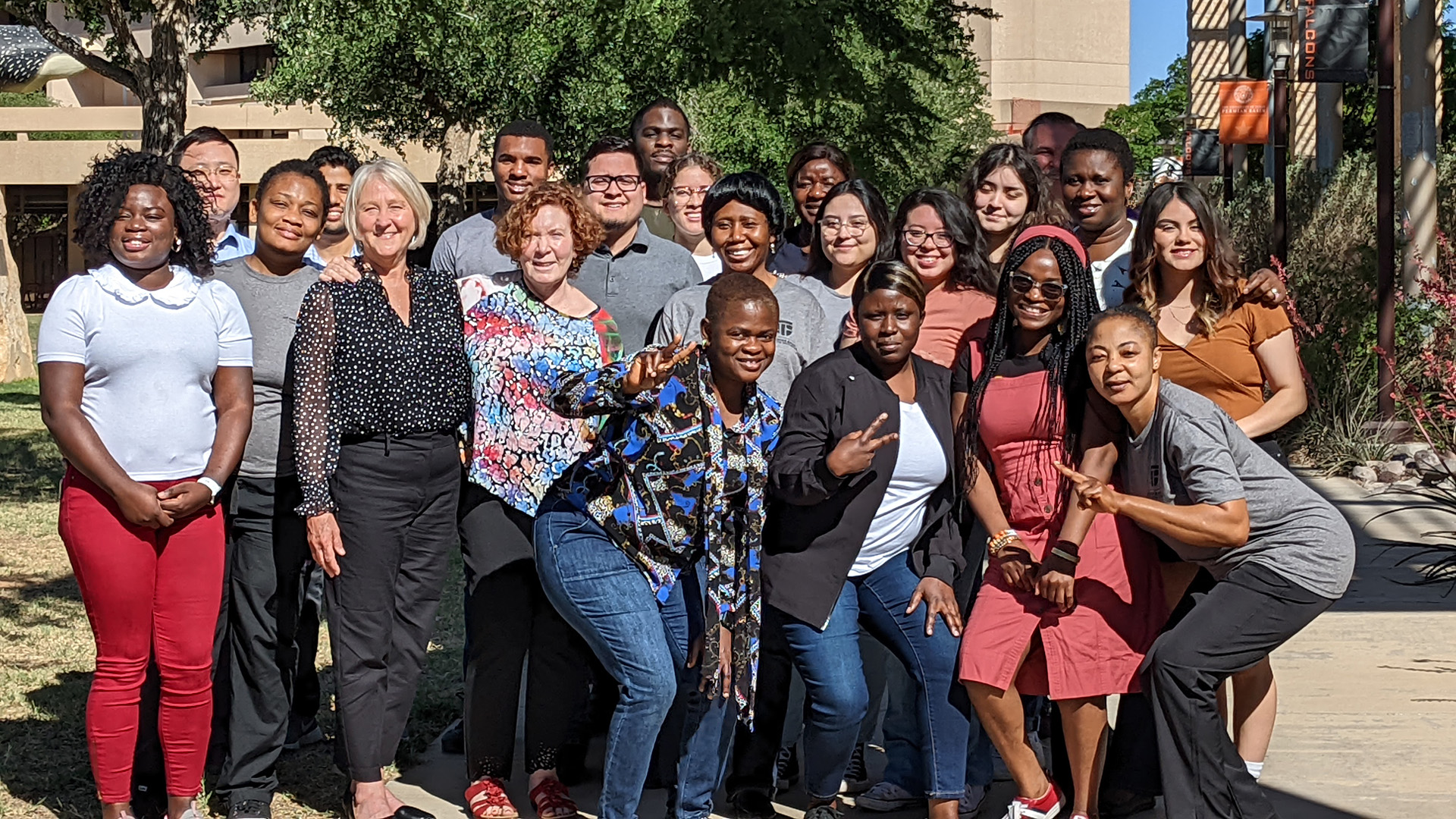 Group of individuals smiling and posing together outdoors during a UTHealth Houston GET PHIT student engagement community event.
