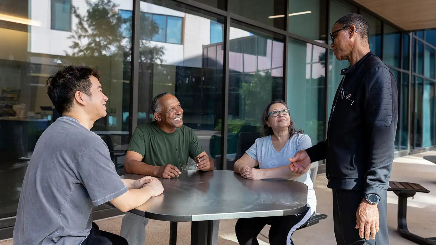 Group sitting around a table outside having a discussion