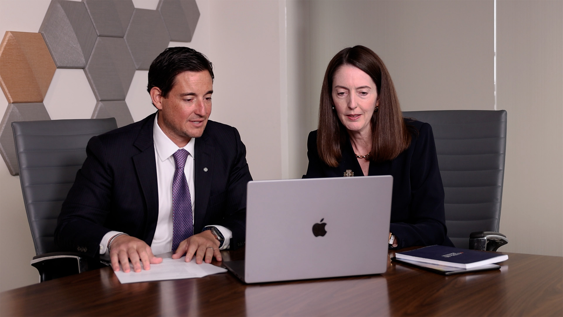 Michael Patriarca (left) meets with UTHealth Houston President Melina Kibbe (right) as they review information on a laptop during a meeting.
