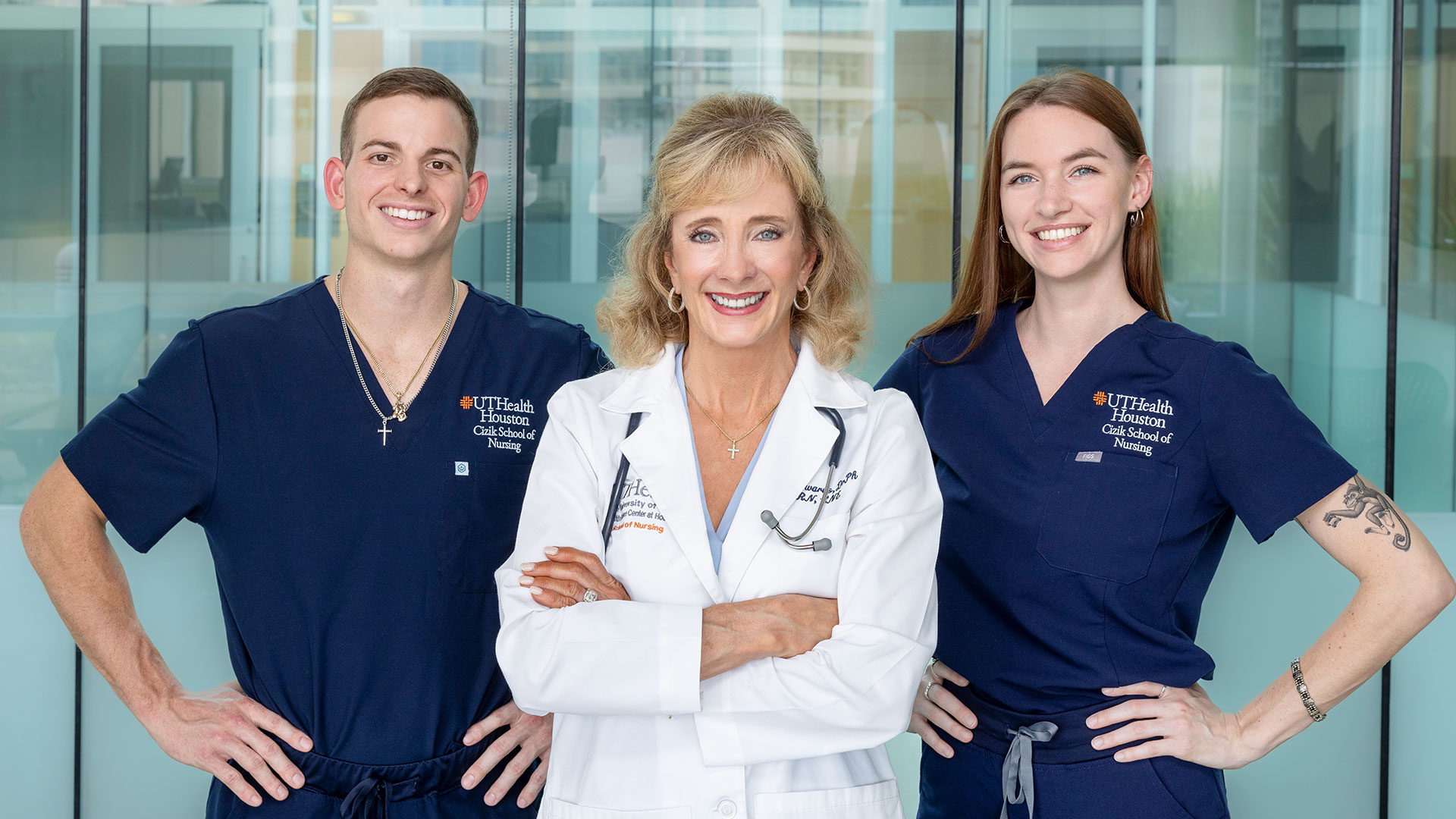 Three healthcare professionals from Cizik School of Nursing standing together in a bright clinical setting, smiling confidently at the camera.