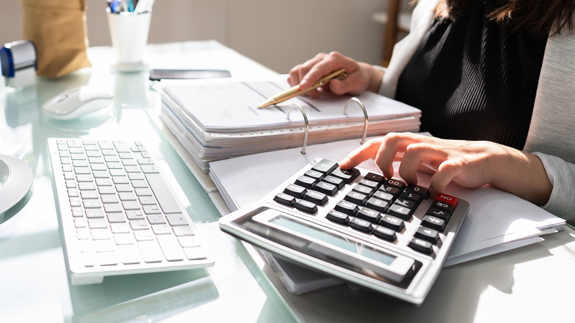person sitting at their desk with a calculator