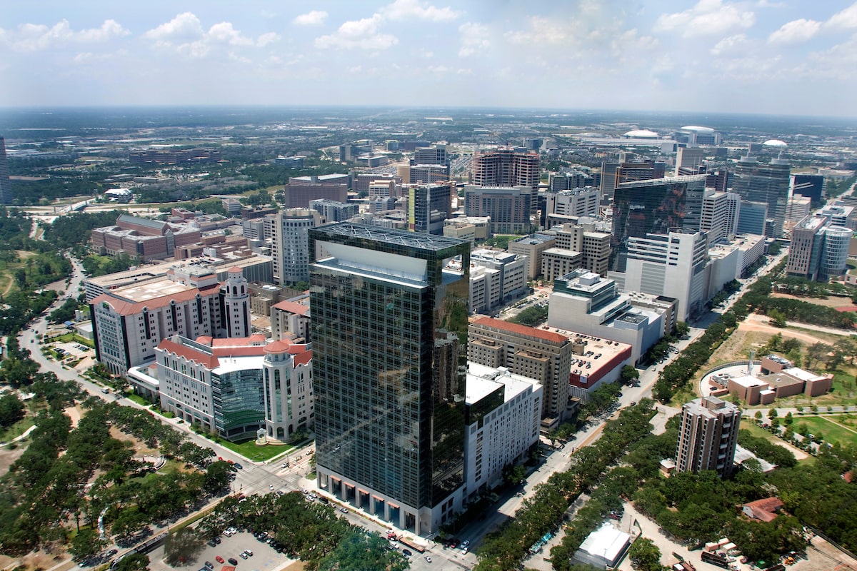 An aerial shot of the UTHealth Houston University Center Tower North, a tall, black, and reflective building.