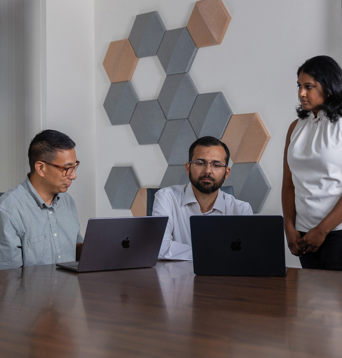 Center for Digital Healthcare Innovation team members gathered around two laptops on a wooden table