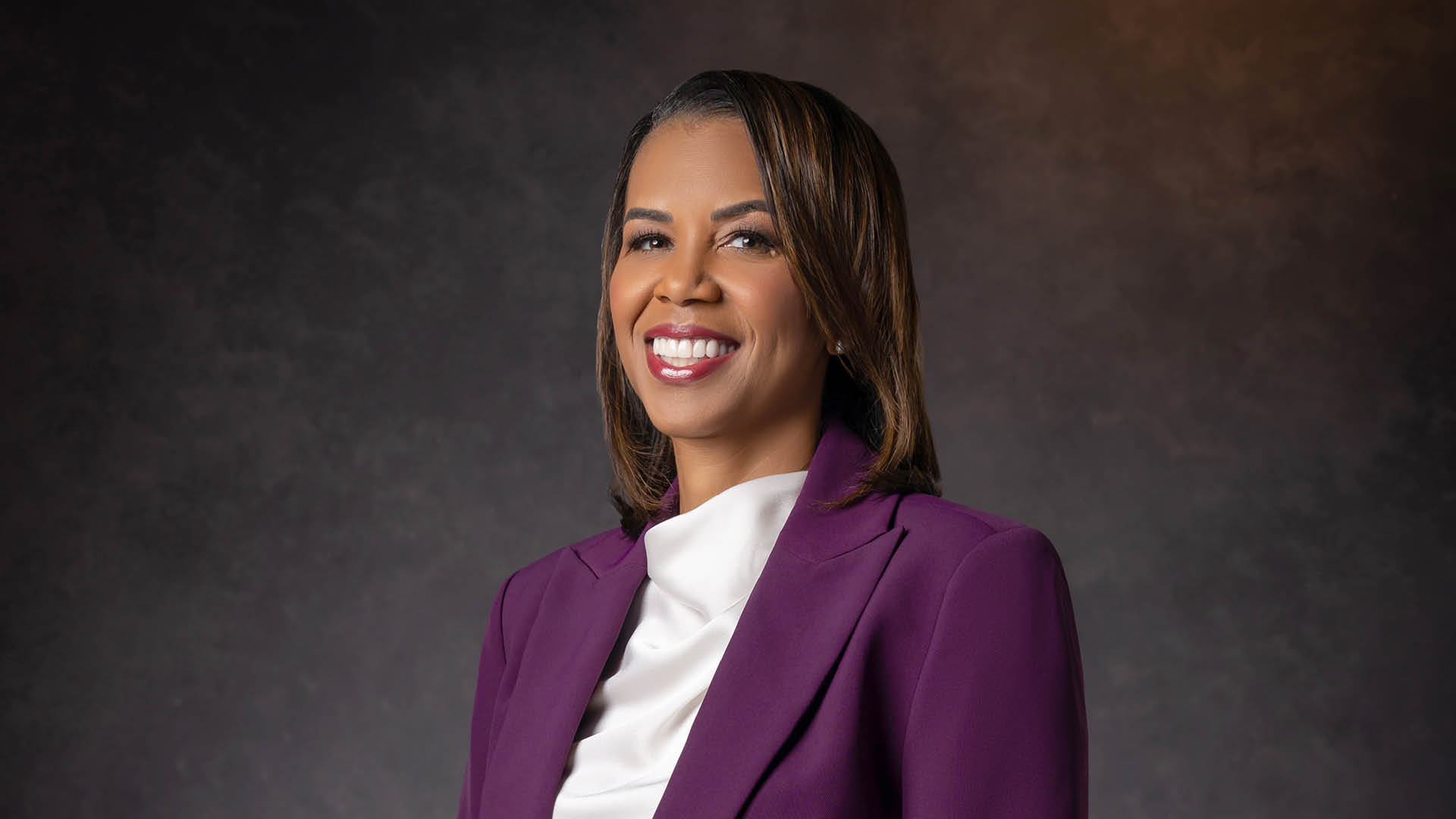 Dean Latanya Love of McGovern Medicine School at UTHealth Houston wearing a purple blazer inside a photo studio