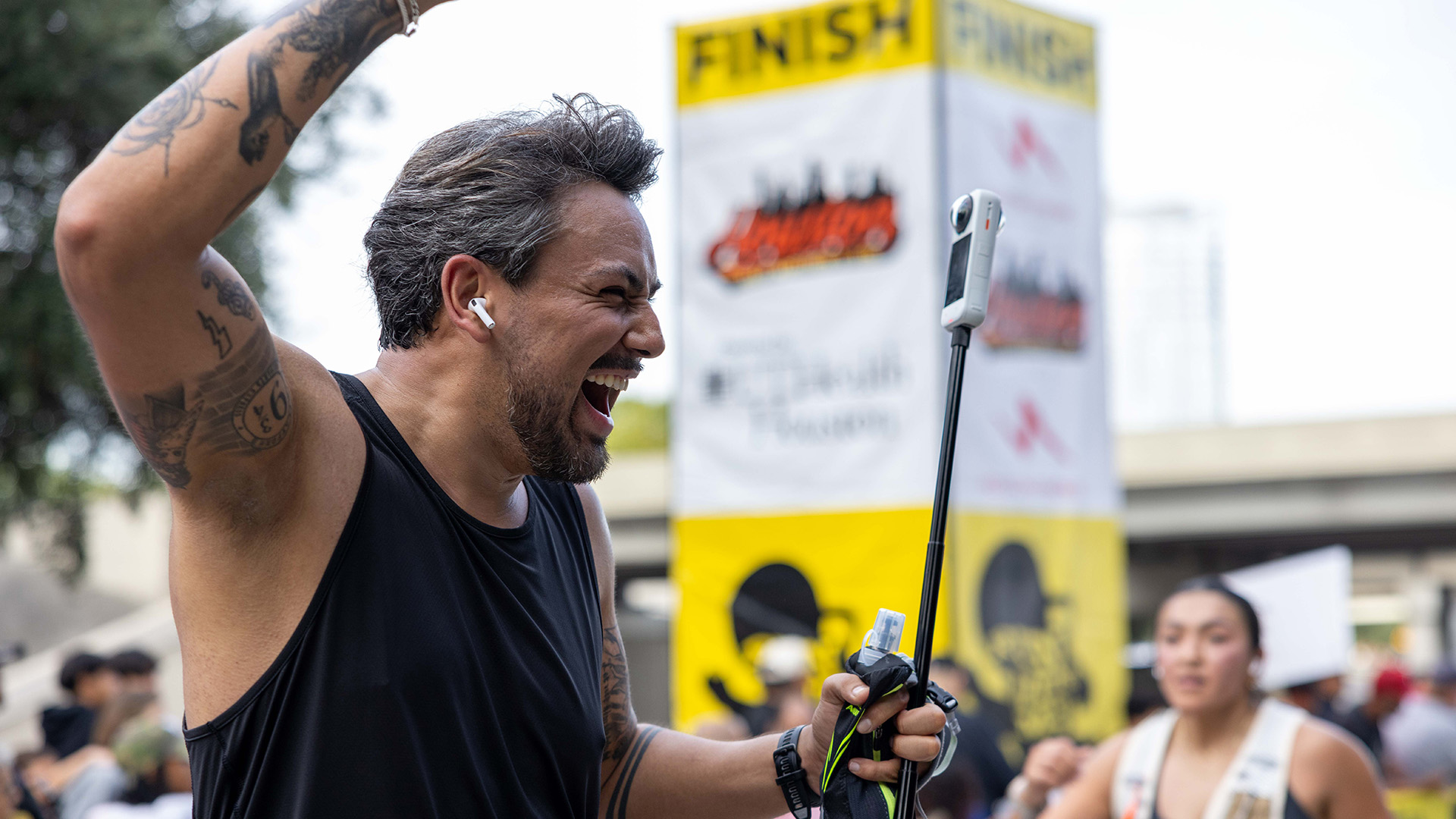 Runner celebrates with his arm raised as he approaches the Houston Half Marathon finish area.