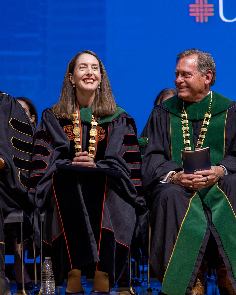 President Melina Kibbe smiles on stage in academic regalia during her investiture as president of UTHealth Houston.